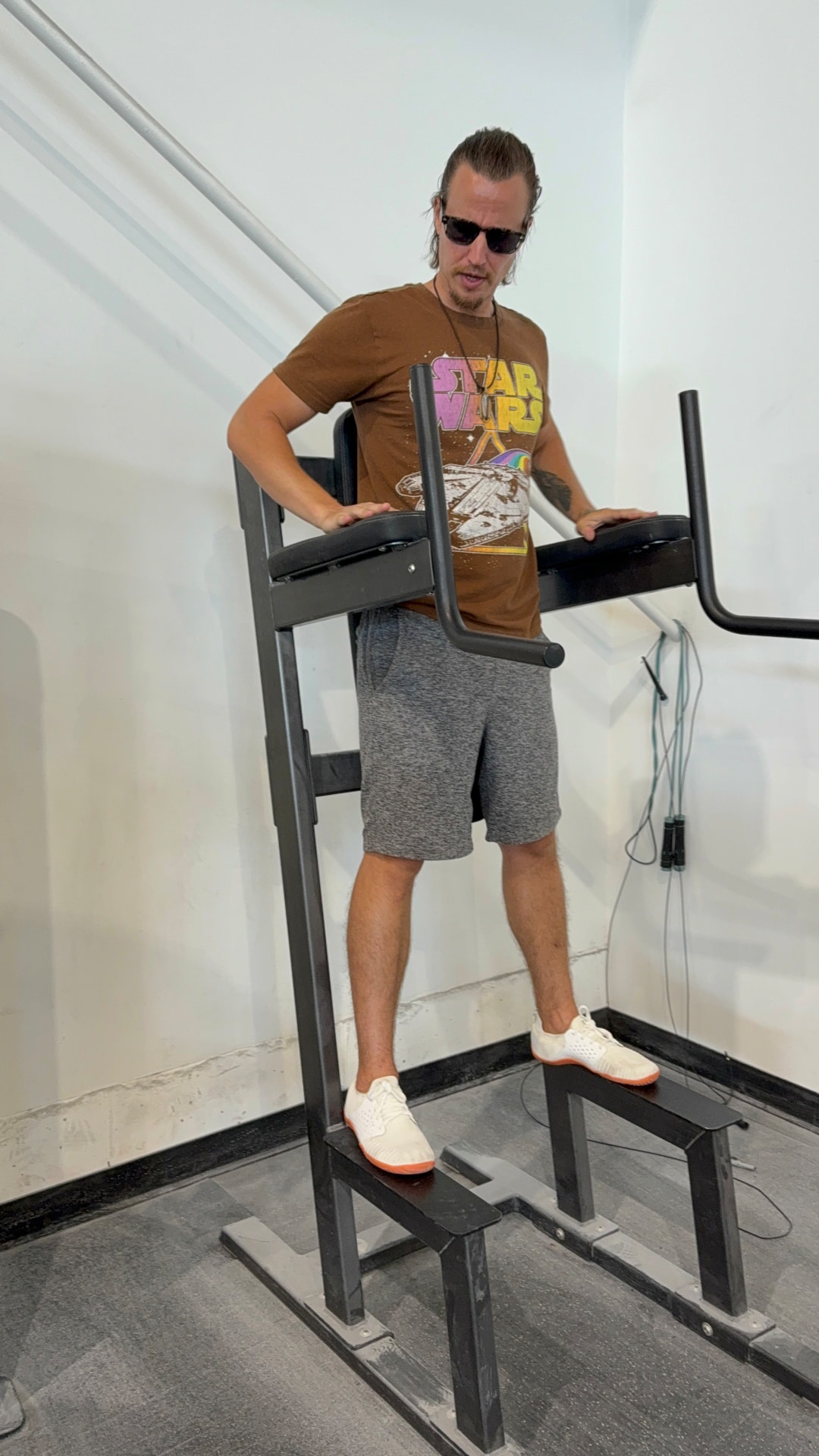 Kai in a Star Wars shirt and sunglasses on gym equipment